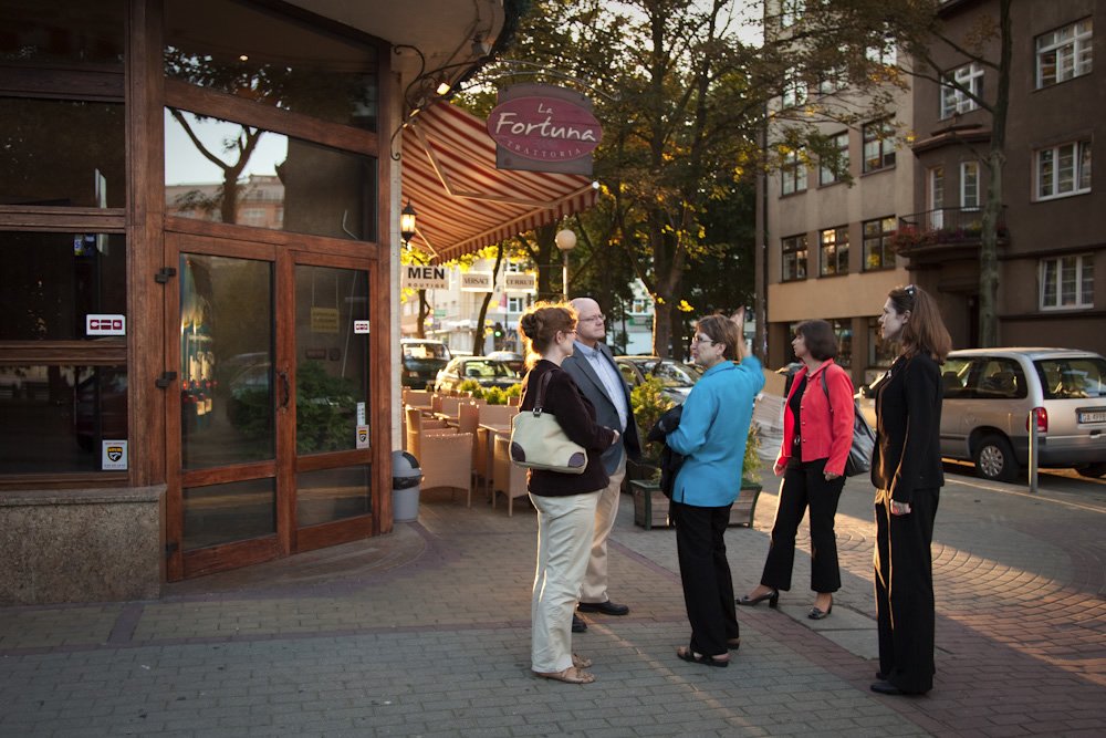 A group of friends chat outside a quaint cafe in the Pacific Northwest during a leisurely day.