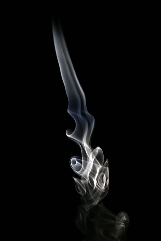 Abstract smoke forming ghostly patterns against a black background. Ethereal spirit-like design captured in monochrome tones.