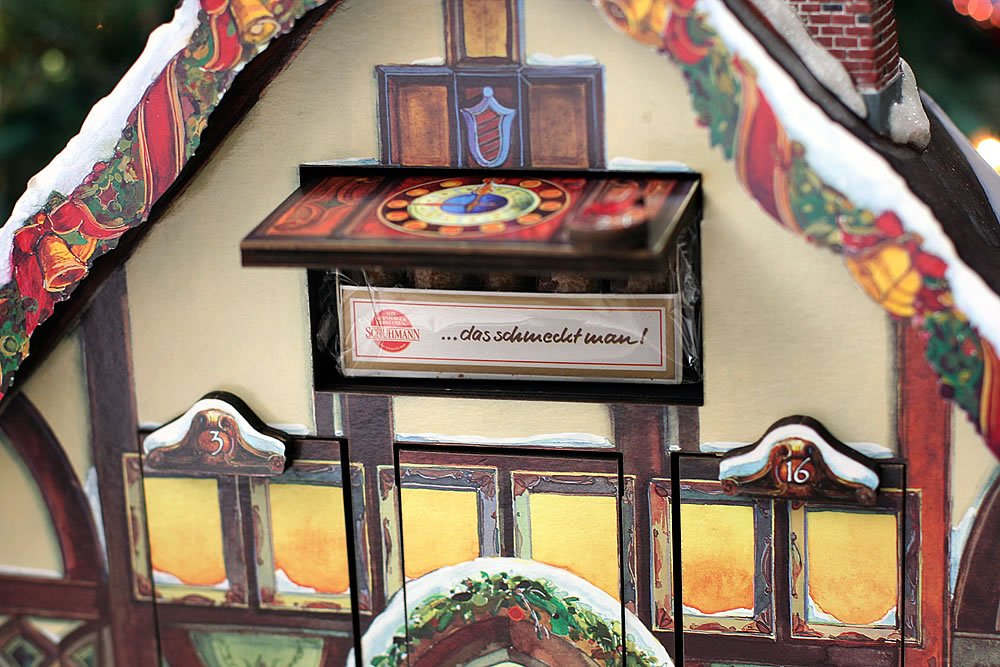 A close-up of a gingerbread house featuring festive decorations and a snowy design.