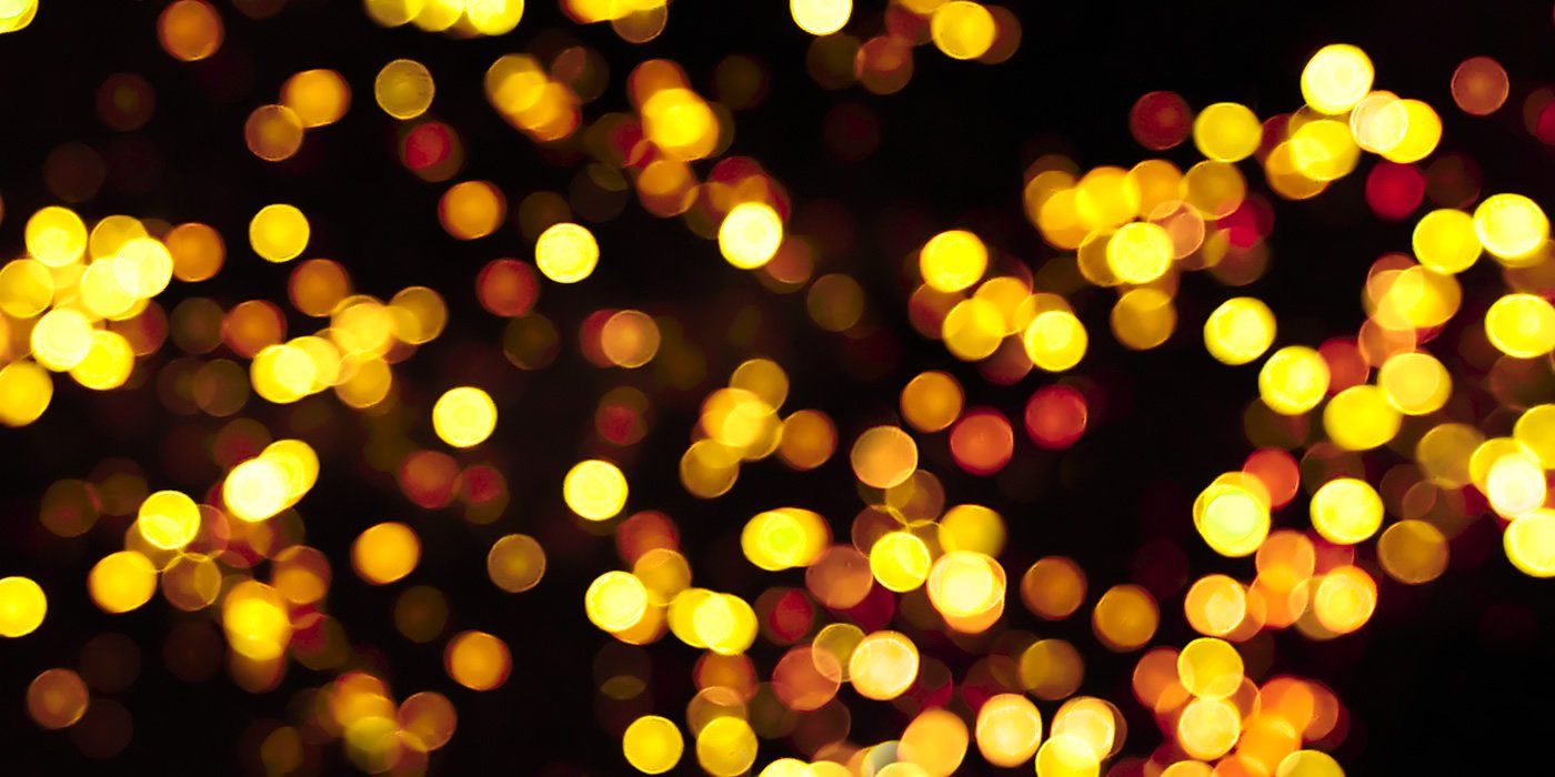 Fourth of July Abstract image showcasing golden bokeh lights against a dark background, creating a magical and festive atmosphere.