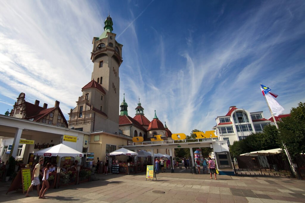 A vibrant town square featuring a picturesque tower and bustling market stalls.
