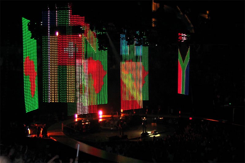 Vibrant LED structures illuminated with festive designs in shades of red and green.