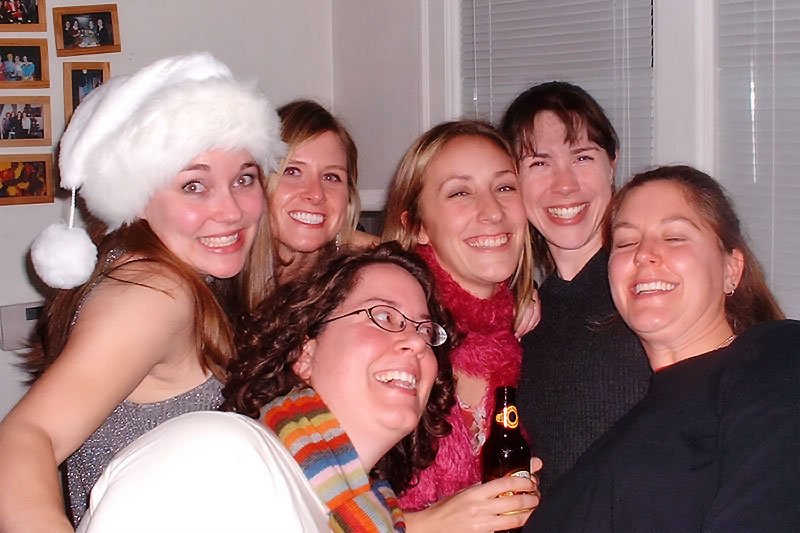 A group of smiling friends celebrating a holiday gathering together.