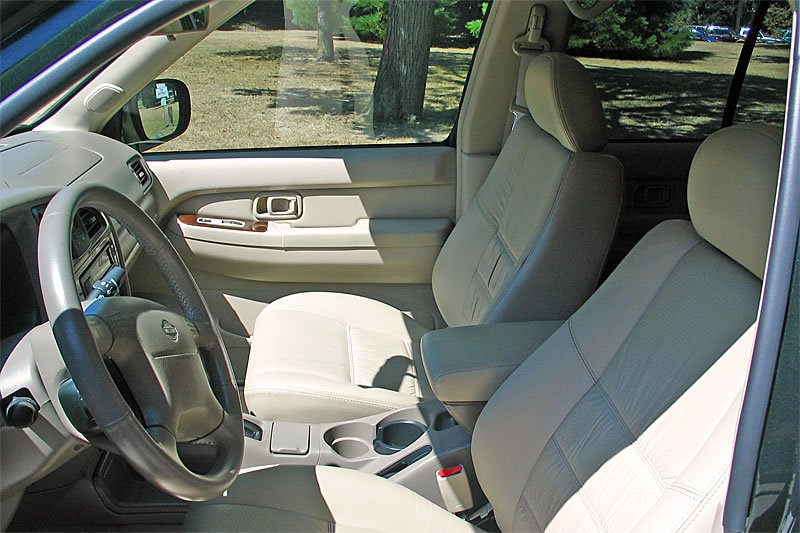 This image shows the beige interior of a car with a steering wheel on the right side.