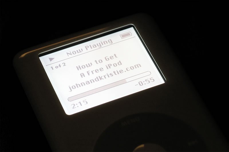 A close-up view of an iPod screen playing a podcast titled 'How to Get A Free iPod' from johnandkristie.com, highlighting the blog’s early tech and travel themes.