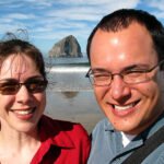 Silver Falls A couple smiling at the beach with Haystack Rock in the background.
