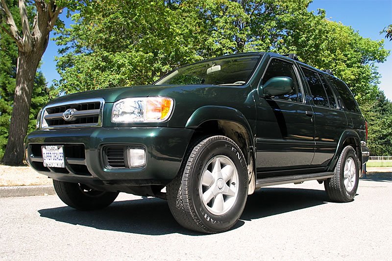 A forest setting with a green SUV parked among the trees, symbolizing an adventurous outdoor expedition.