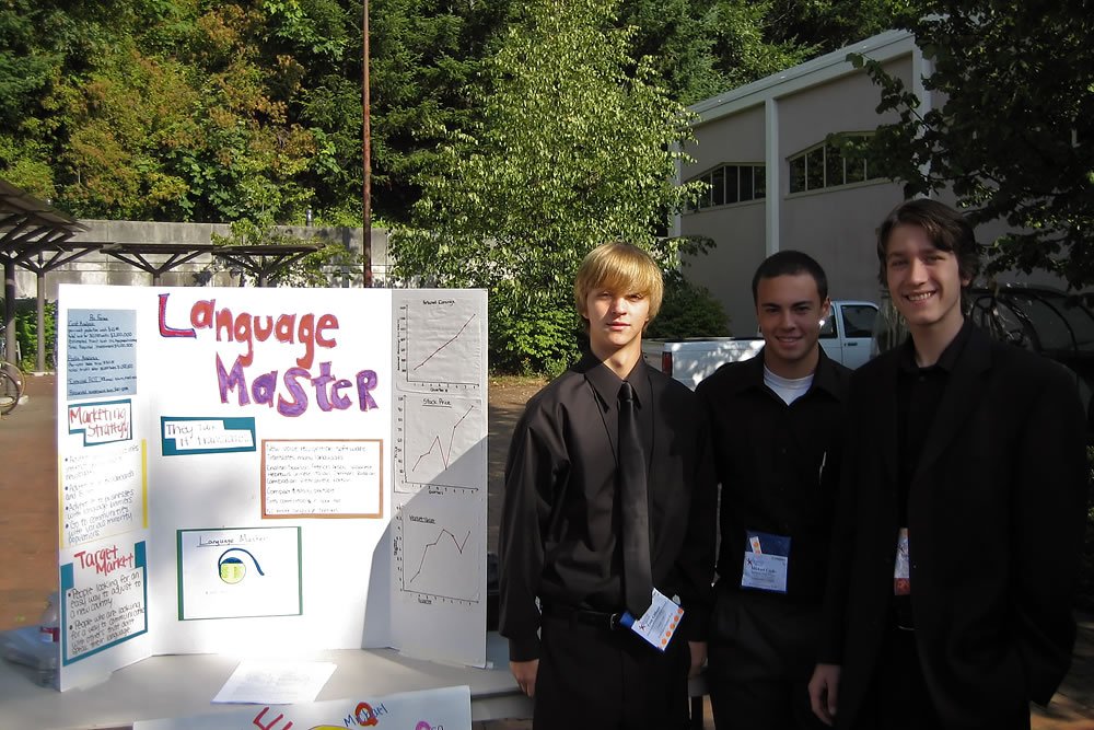 John and Kristie stand with friends at a school science fair, showcasing pride and support.