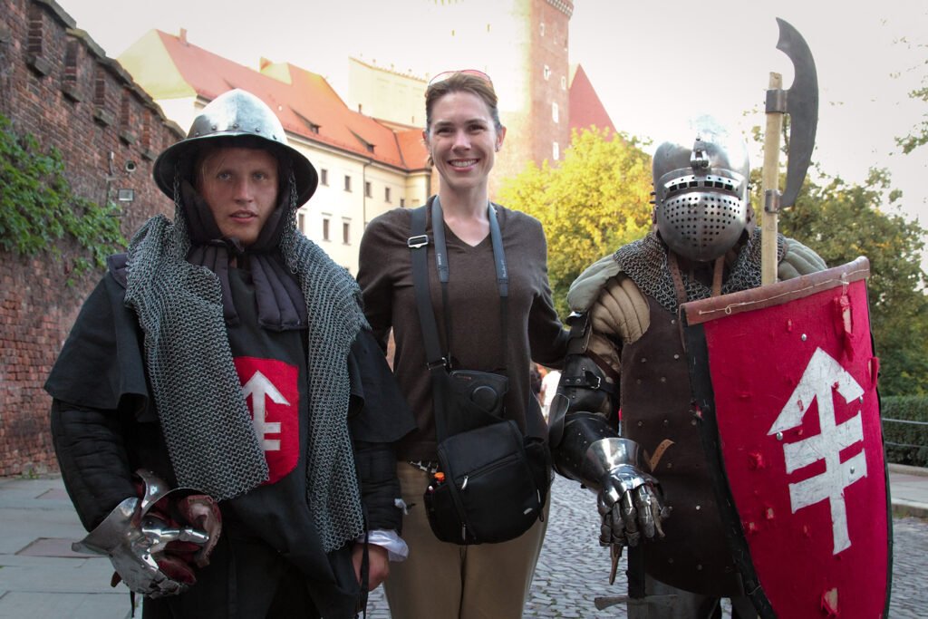 A photo of John and Kristie posing with two medieval reenactors holding shields and weapons.