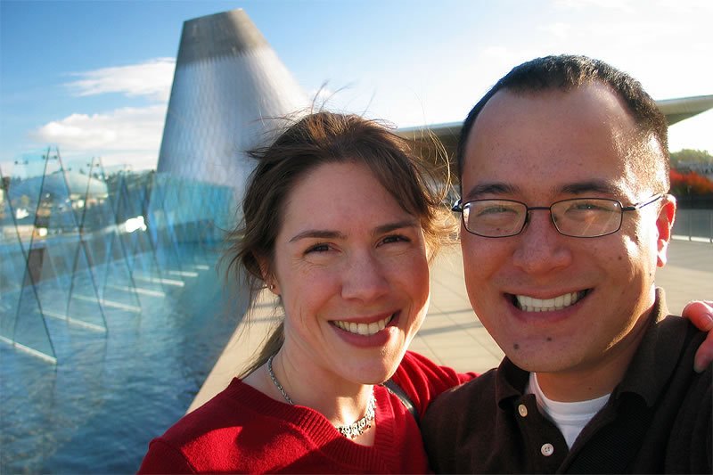 Kristie and John taking a selfie in front of a large aircraft.