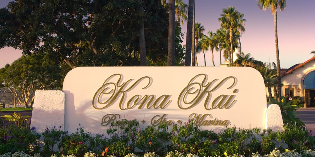An image showing the entrance sign of the Kona Kai Resort and Spa amidst tropical greenery.
