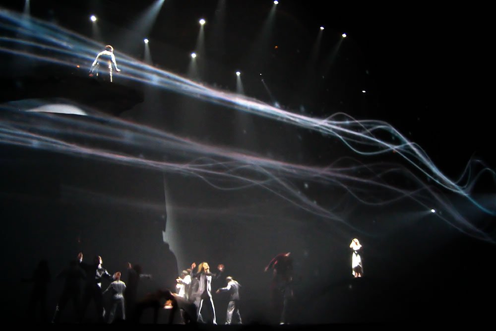 A dazzling display of light trails and spotlights at a live concert or performance event.
