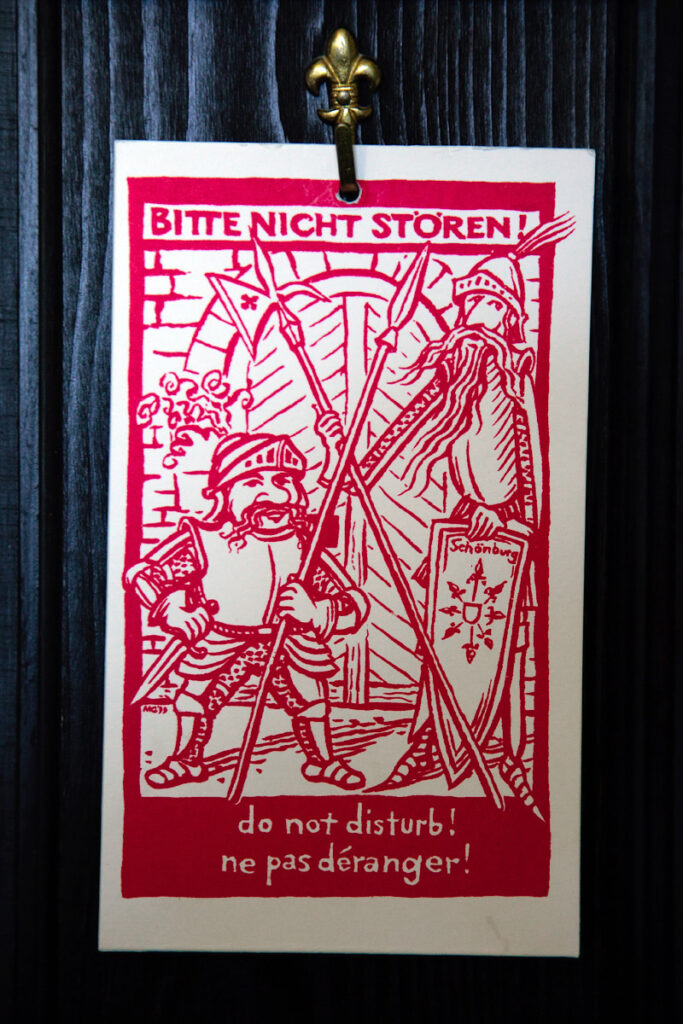 A fun 'do not disturb' sign featuring two medieval knights holding weapons and shields.