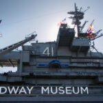 Calcite Mine The Midway Museum, featuring a historic aircraft carrier with its distinctive superstructure and flags flying high.