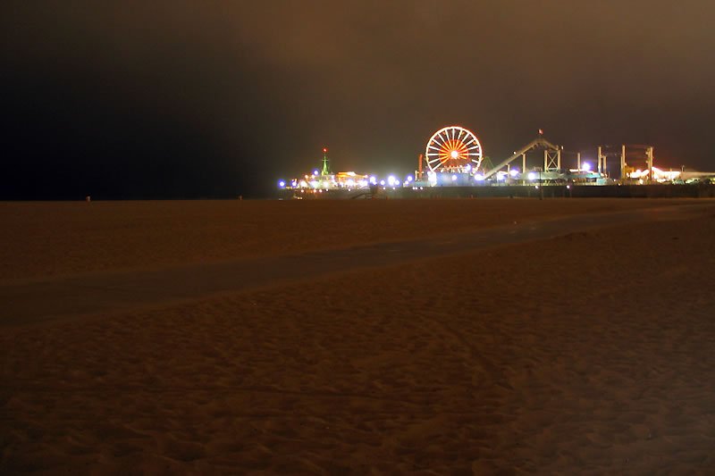 A nighttime view of New Brighton Pier illuminated with colorful lights including a prominent Ferris wheel.