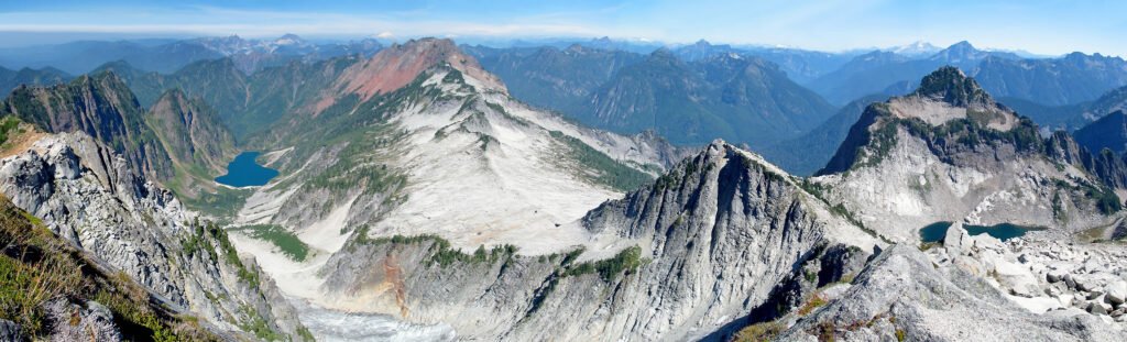 Panoramic view of rugged mountain peaks and a serene lake below.