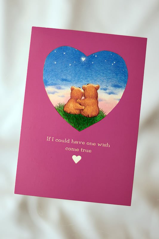 A bright pink greeting card featuring two teddy bears inside a heart under a starry sky with the text, 'If I could have one wish come true.'