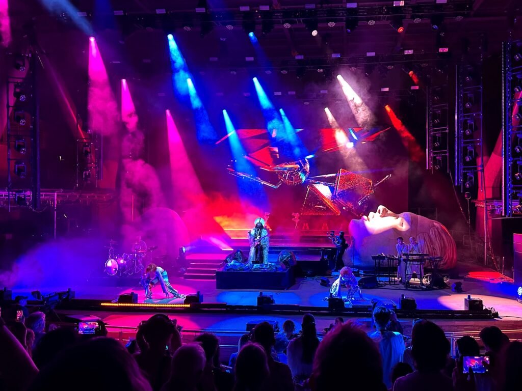 Performers dressed as Power Rangers on a brightly lit stage in front of an audience.