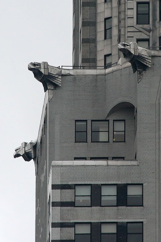 A close-up view of the iconic gargoyle eagles perched on the cantilevered cornices of a historic Seattle skyscraper.
