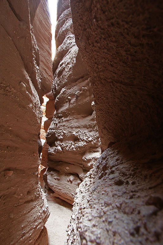 A snowy canyon features towering rocky peaks in the background.