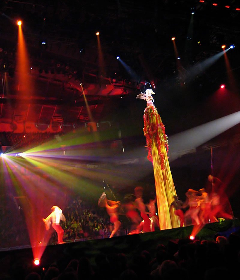 A dynamic stage performance featuring colorful lights and energetic dancers under spotlights.