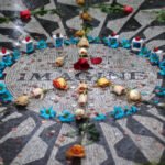 Washington, D.C. A close-up of the 'Imagine' mosaic in Central Park adorned with flowers and candles as a tribute.