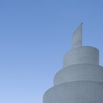 Dallas Arboretum A close-up view of a white stupa tower against a clear blue sky, showcasing its unique architectural details.