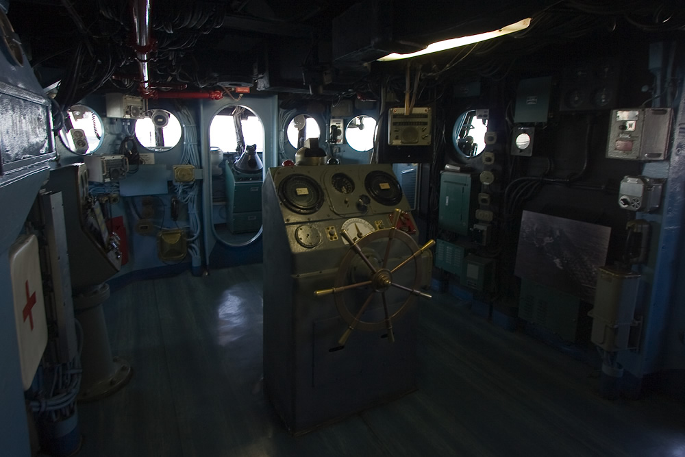 A view of the interior of a vintage submarine, showcasing the control panels and circular portholes.