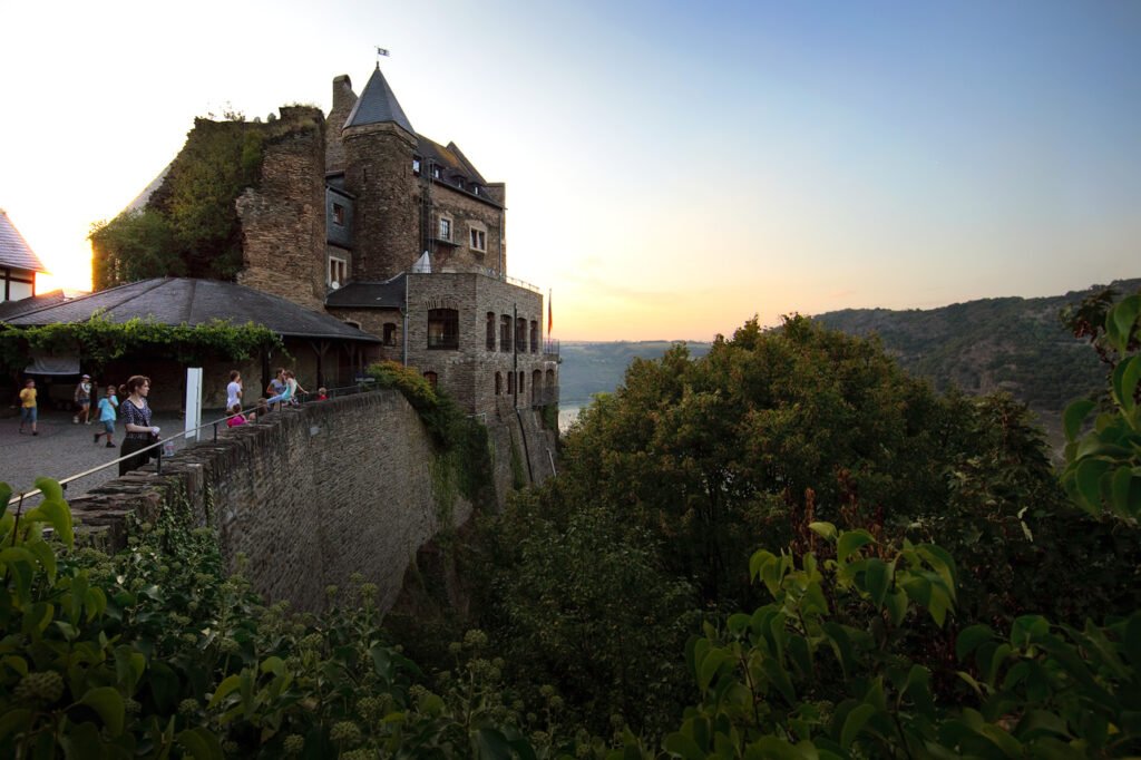 A beautiful sunset view from the terrace of Castello di Amorosa, surrounded by lush greenery.