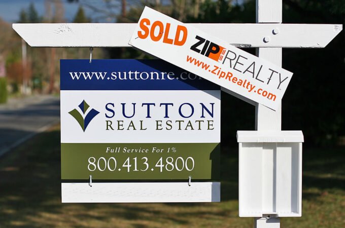 A 'Sold' sign displayed on a real estate property featuring the Sutton Real Estate branding and contact information.
