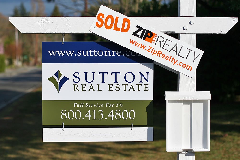 A 'Sold' sign displayed on a real estate property featuring the Sutton Real Estate branding and contact information.