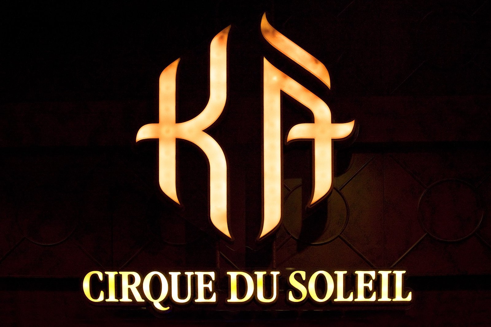 Cirque du Soleil: KA A woman in traditional Japanese attire energetically strikes a large taiko drum with a mallet during a live performance.