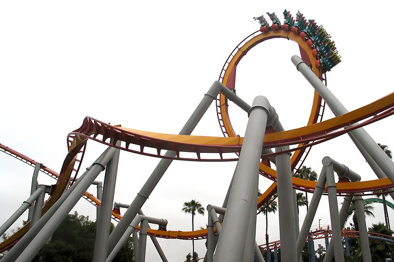 A high-speed roller coaster soaring through loops and drops at an amusement park.