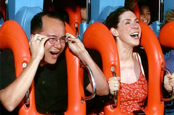 Enjoying the thrill of a roller coaster ride with friends, laughter and excitement on board.