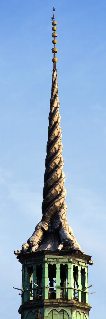 Three views of a distinctive twisted spire on a church tower set against a clear blue sky, showcasing its unique architectural detail.
