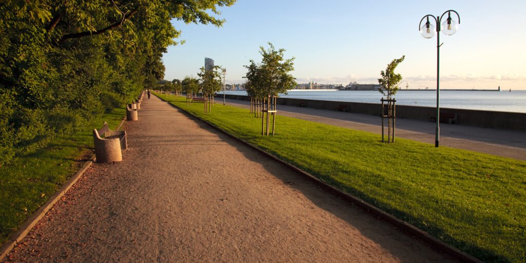 A picturesque waterfront path lined with trees and benches, perfect for a leisurely stroll.