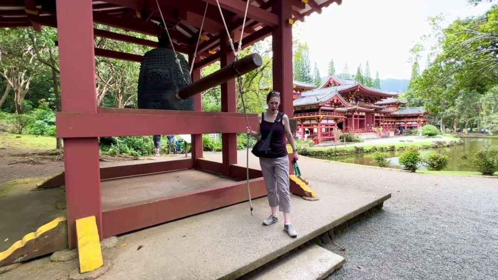 Travelers explore the red pagoda temple grounds in Nikko, Japan.