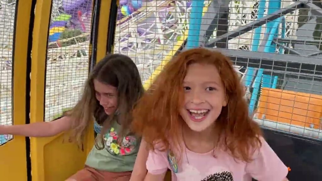 Two children enjoying a roller coaster ride at an amusement park