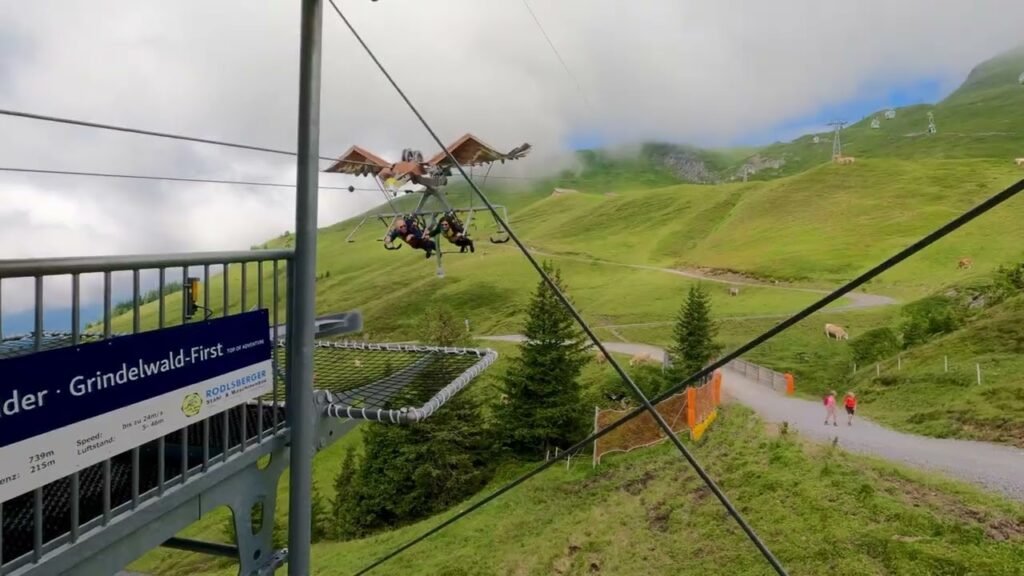 Riders zip line over green hills near Grindelwald Festival.