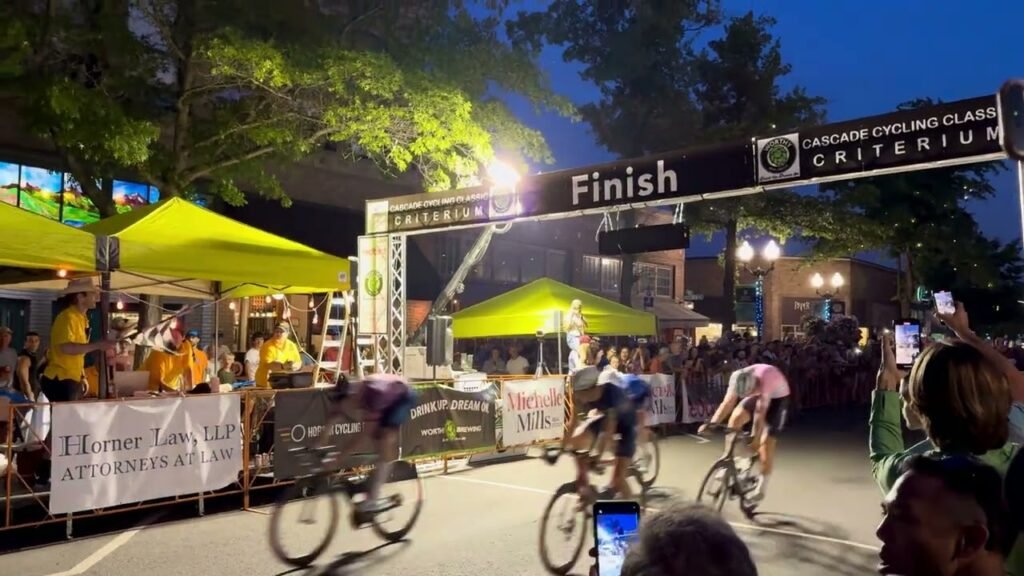 Cyclists race under a Finish line arch during the Canada Cycling Class Criterium at night.