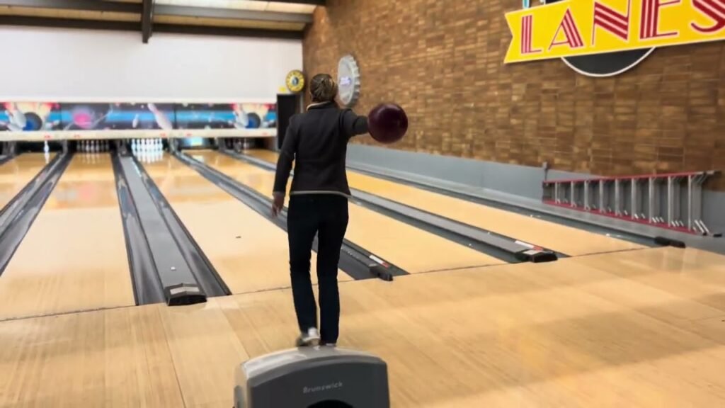 Two people playing a unique bowling game with paddle targets at a local bowling alley called Lanes.