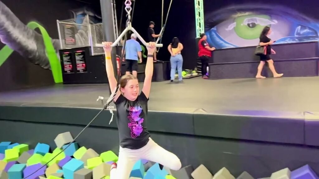 A person is trampoline jumping in an indoor trampoline park.