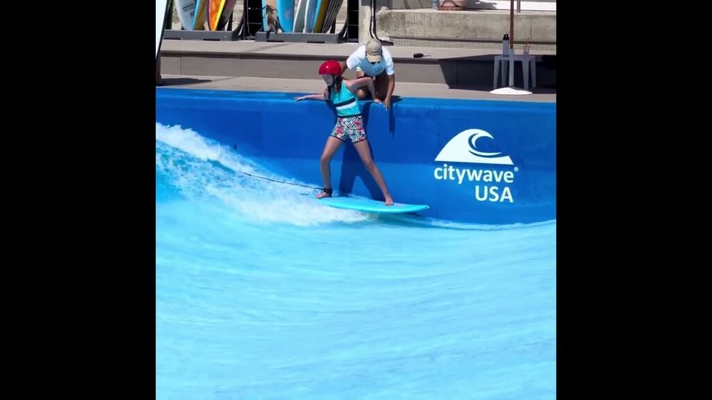 A person riding a wave on a surfboard at the CityWave USA pool.