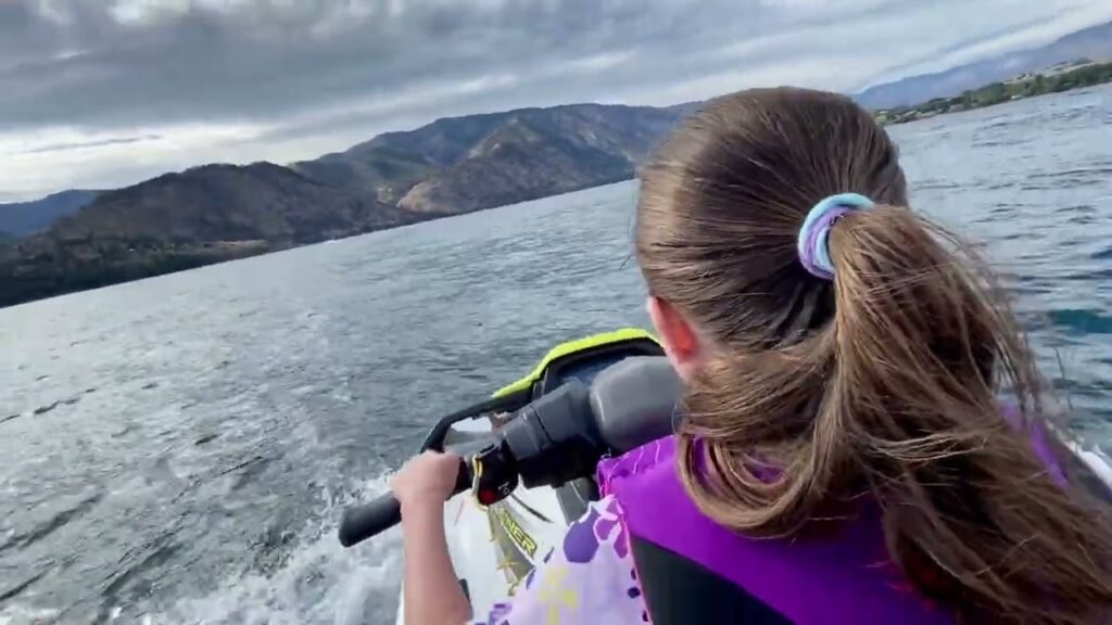 Photos of a child from behind paddleboarding on a lake with mountains in the background.
