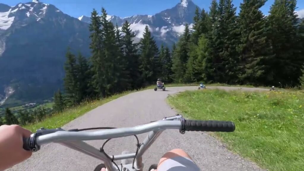 A peaceful bicycle ride on a mountain road amid snow-capped peaks and dense forests.