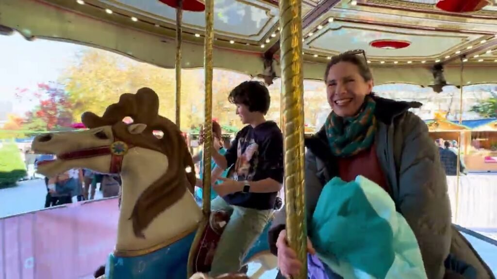 Enjoying a carousel ride at a local fair. Riding a carousel horse at a cozy autumn event.