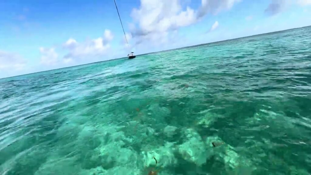 A view of clear turquoise ocean water with a distant boat.