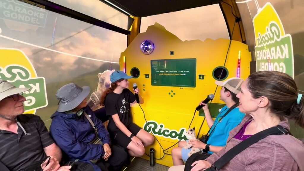 A group of people inside an aircraft, preparing for a skydiving trip. The interior is decorated with karaoke and sponsor branding.