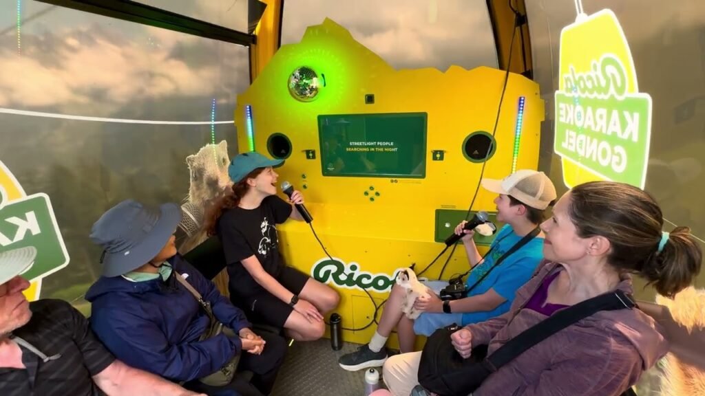 A group of people sings karaoke inside a yellow submarine simulator labeled 'Rico'. A sign indicates the activity in Chinese.