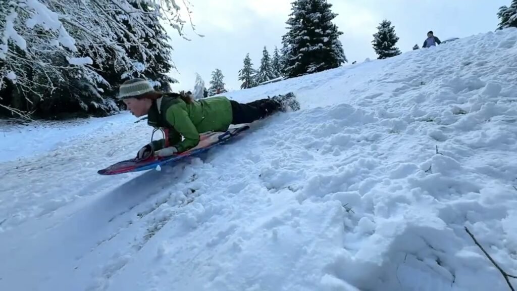 A person snowboarding down a steep, snow-covered slope in the Pacific Northwest mountains.